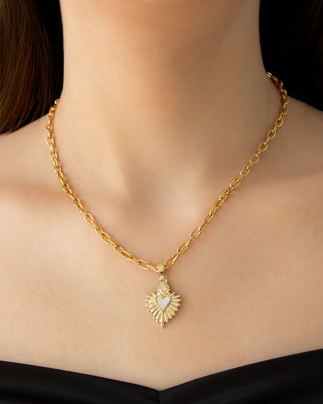 Model wearing gold choker necklace with radiant heart sunburst pendant – vintage statement design.