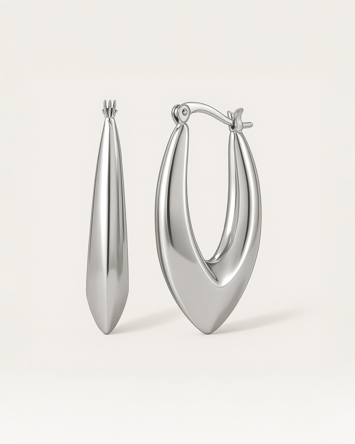 Close-up of sculpted silver hoop earrings in bold marquise teardrop shape with latch-back closure