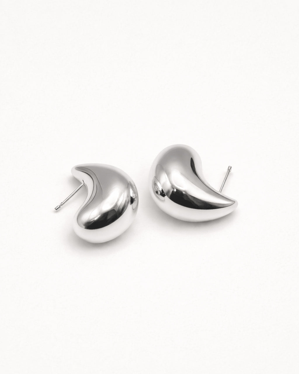 Silver sculpted teardrop stud earrings front view, featuring a polished minimalist design by Jadejuri