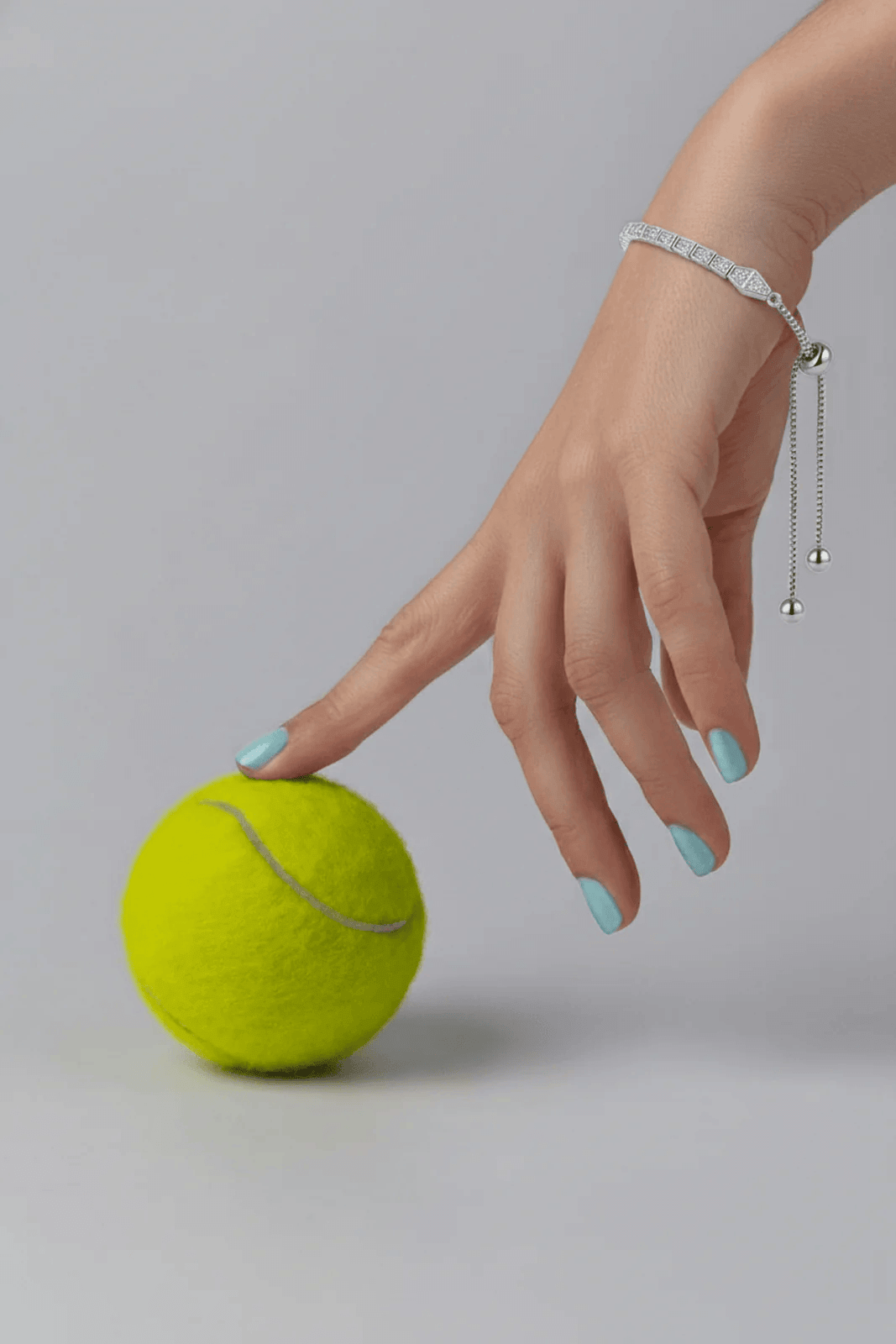 A silver-toned slider bracelet with a delicate chain and a geometric centerpiece. The adjustable bracelet features a row of s