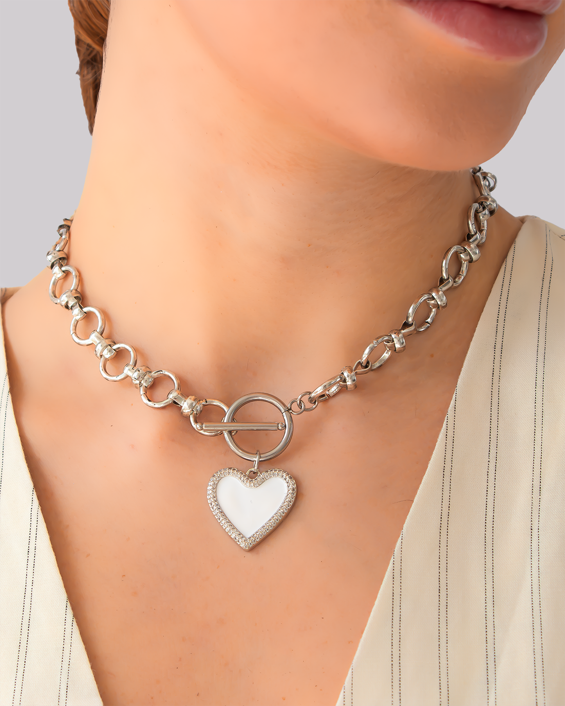 Silver necklace with textured chain and white heart enamel pendant – toggle clasp design with pavé detailing.