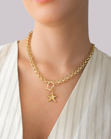 Gold star pendant chain necklace worn on model, featuring a chunky gold chain and star charm necklace by Jadejuri