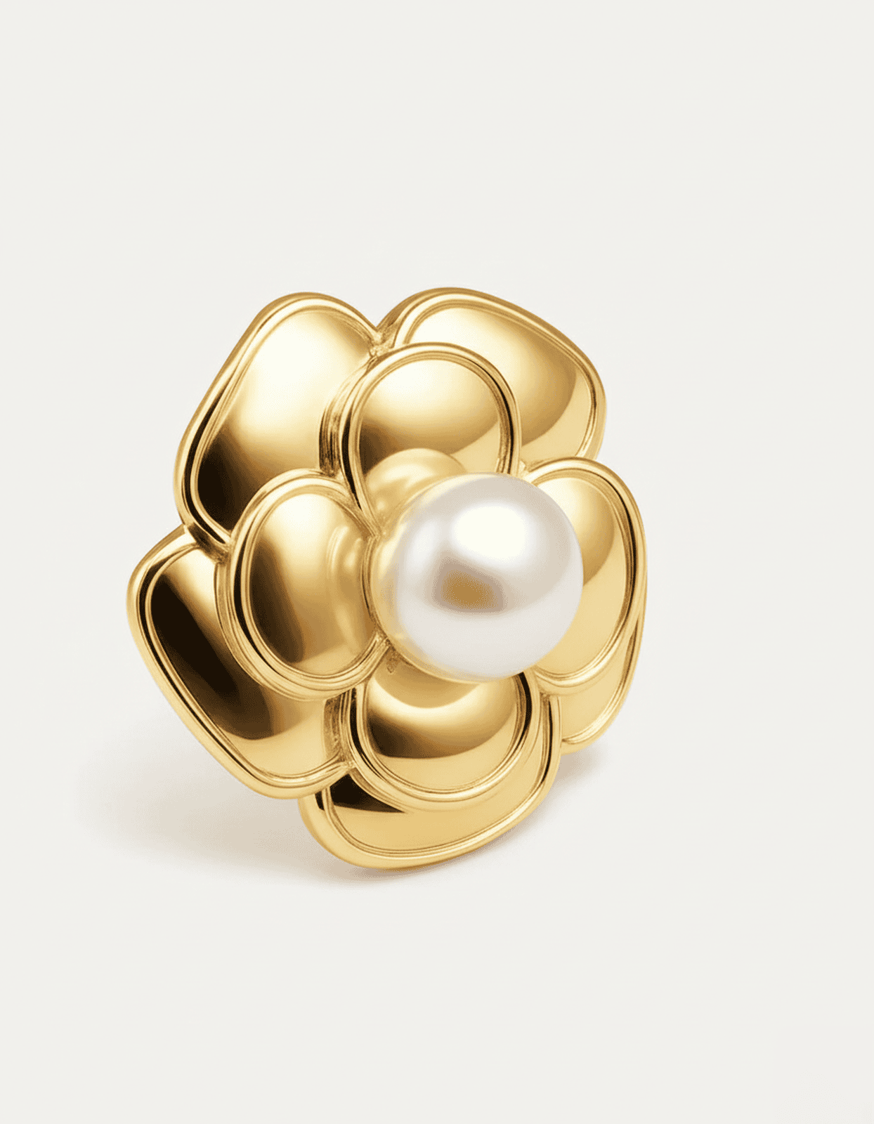 A close-up studio shot of a single gold-tone flower stud earring on a plain white or light beige background. The earring feat