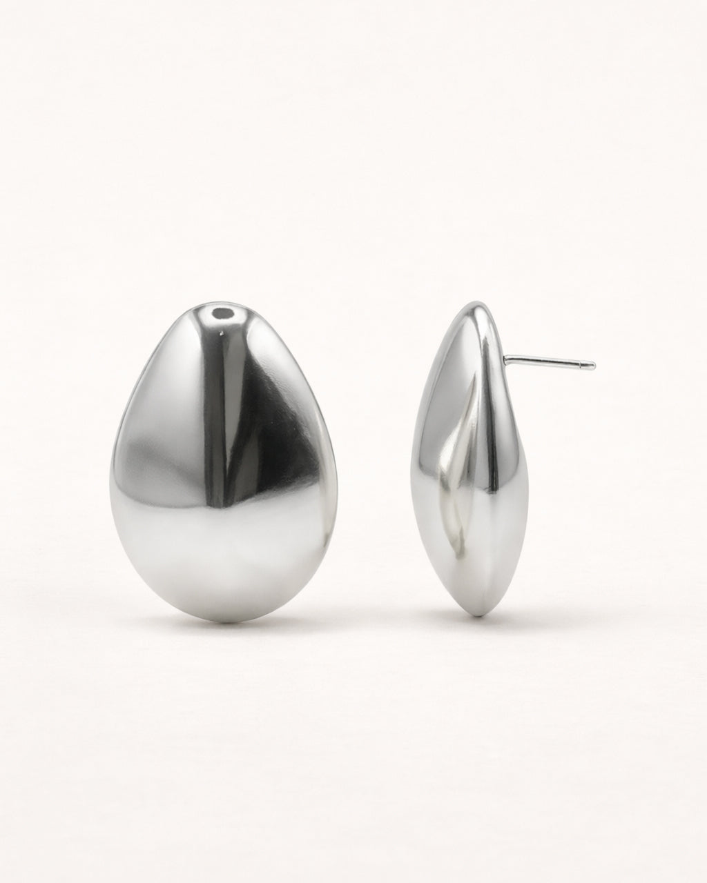 Silver sculpted teardrop stud earrings front view, featuring a smooth polished minimalist design by Jadejuri