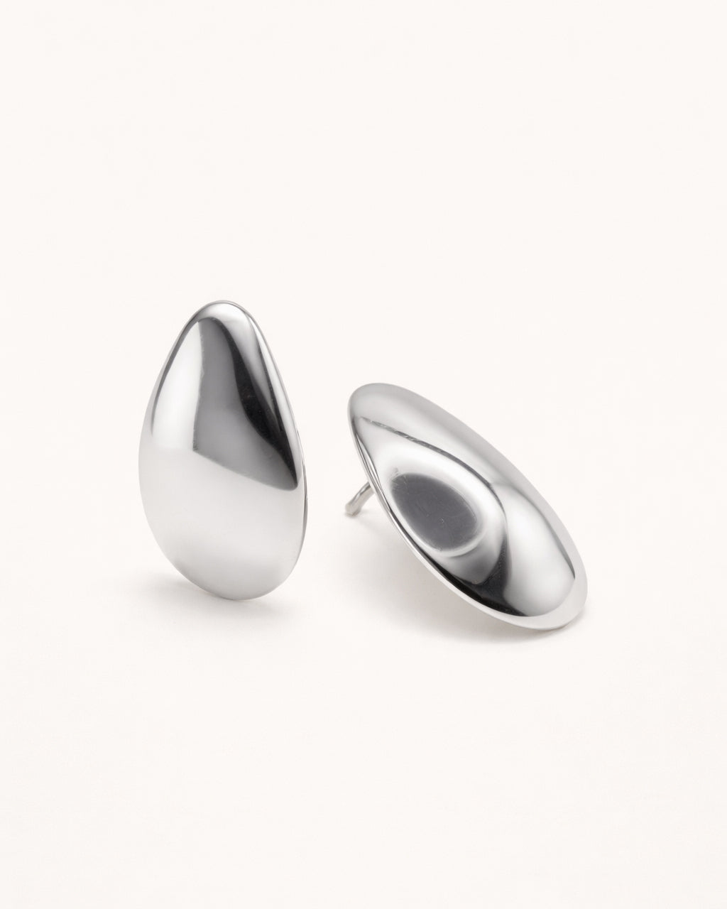 Silver sculpted teardrop stud earrings front view, featuring a smooth polished minimalist design by Jadejuri