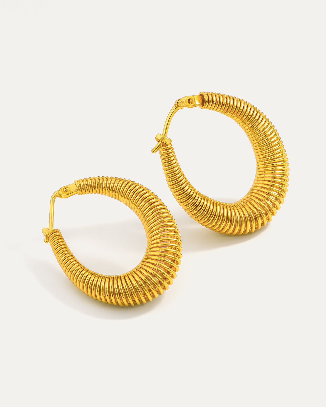Gold hoop earrings on a light beige background