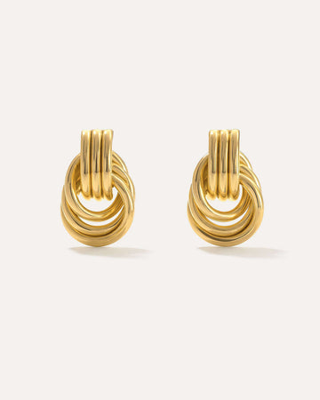 Gold knot earrings on a light beige background